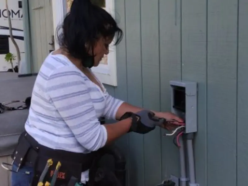 Licensed electrician wiring an exterior subpanel in St. Johns